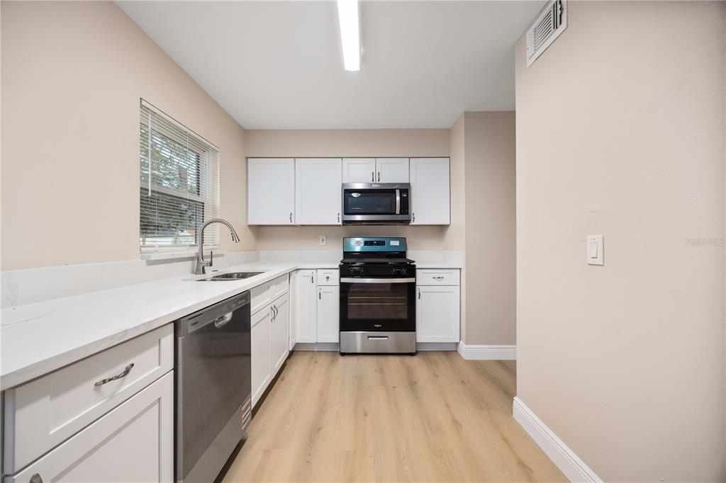 8013 Rhea Circle Orlando, FL 32807 - Photo 8 of 31 a kitchen with granite countertop a stove top oven and sink