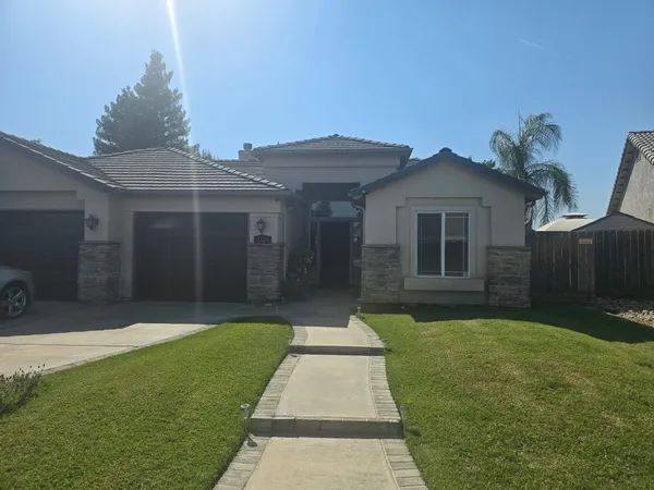 a front view of a house with a garden and yard