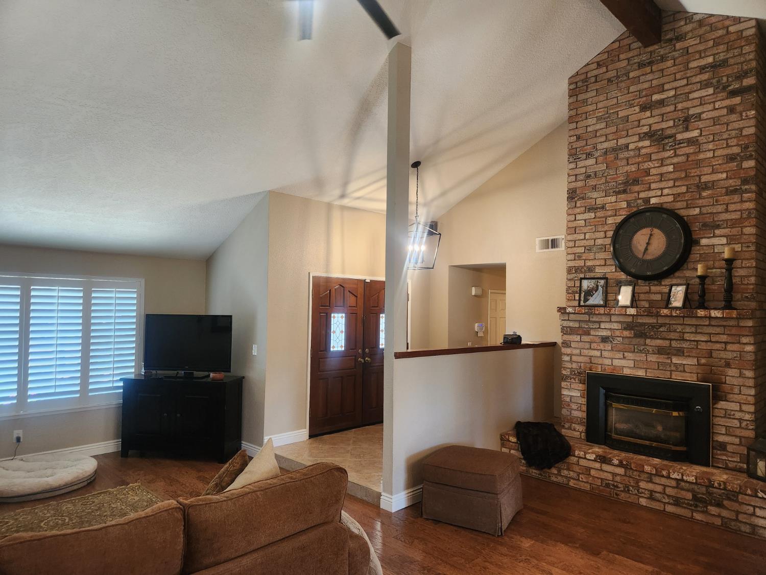 777 Jordanolo Drive Ripon, CA 95366 - Photo 10 of 61 a living room with furniture a flat screen tv and a fireplace