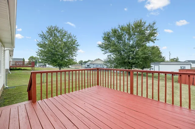 a balcony with wooden floor and trees in the background