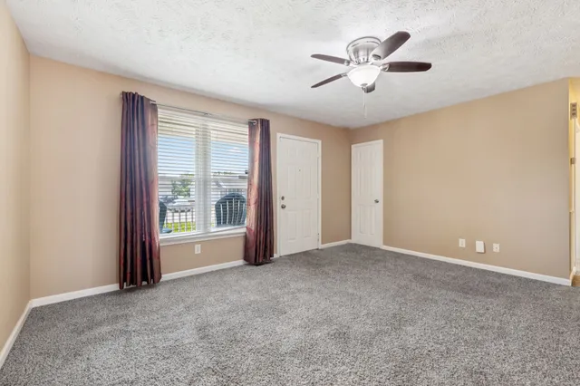 a view of a livingroom with a ceiling fan and window
