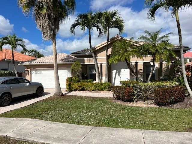 a view of a house with a yard and a palm tree