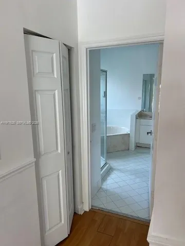 a view of hallway with bathroom and a sink