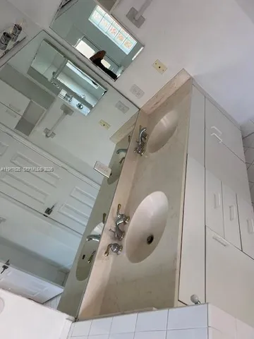 a large bathroom with a large mirror shower and sinks