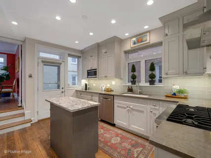 a kitchen with a stove sink and cabinets