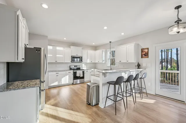 a kitchen with stainless steel appliances granite countertop a refrigerator and a stove top oven