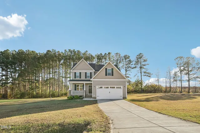 a front view of a house with a yard and trees