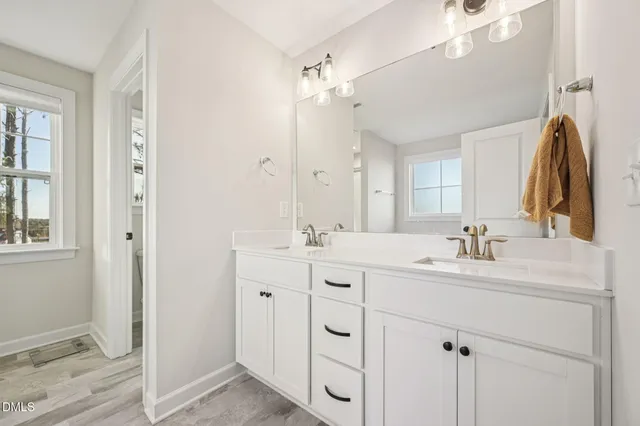 a bathroom with a double vanity sink mirror and