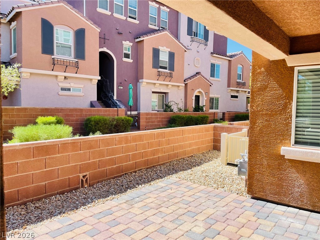 9921 Sable Point Street Las Vegas, NV 89178 - Photo 39 of 43 Brick block walls frame a private paved patio overlooking the neighborhood complex.