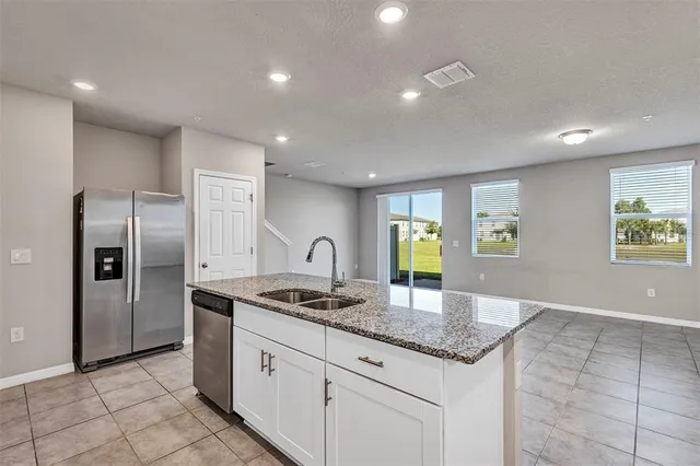 a large kitchen with a large counter top stainless steel appliances and cabinets