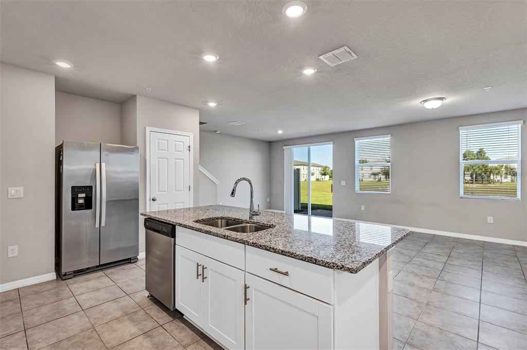 1073 Desert Candle Drive Ocoee, FL 34761 - Photo 11 of 55 a kitchen with stainless steel appliances granite countertop a sink and a refrigerator