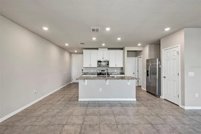 a view of kitchen with cabinets and refrigerator