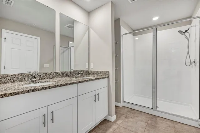 a bathroom with a granite countertop sink and a toilet