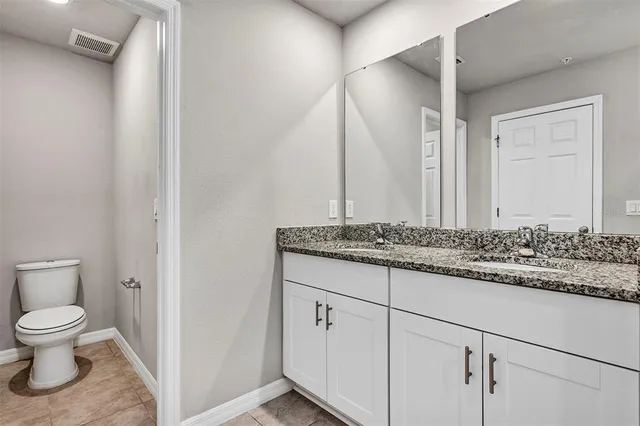 a bathroom with a granite countertop sink a toilet and shower