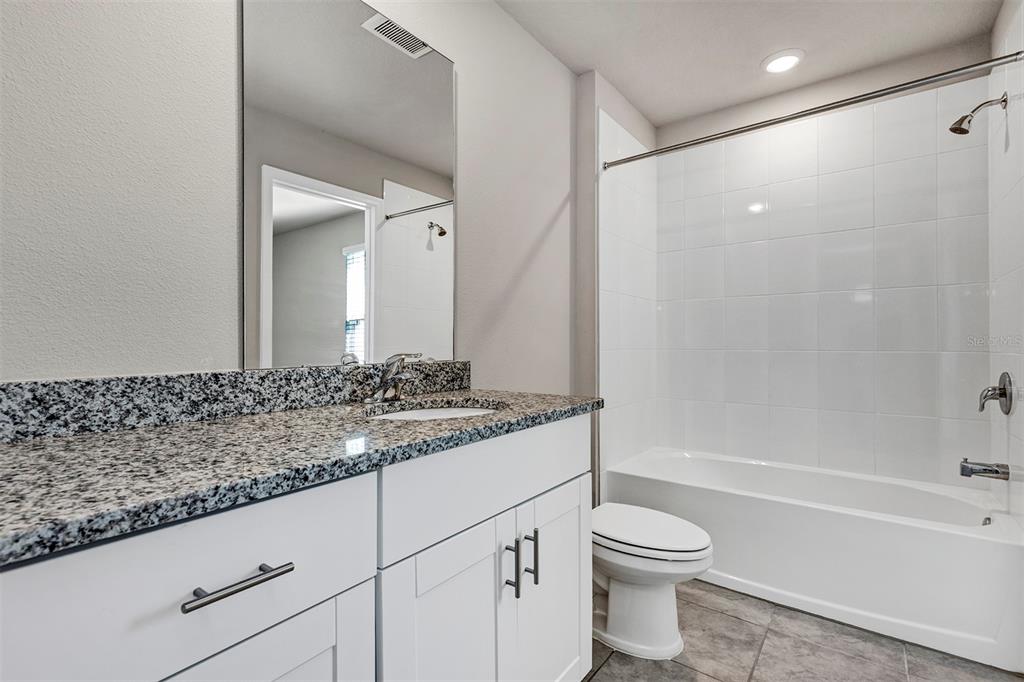 1073 Desert Candle Drive Ocoee, FL 34761 - Photo 23 of 55 a bathroom with a granite countertop sink a toilet and shower