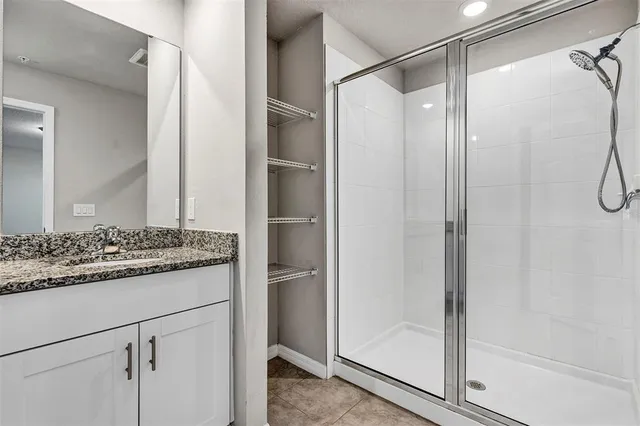 a bathroom with a granite countertop toilet and a sink