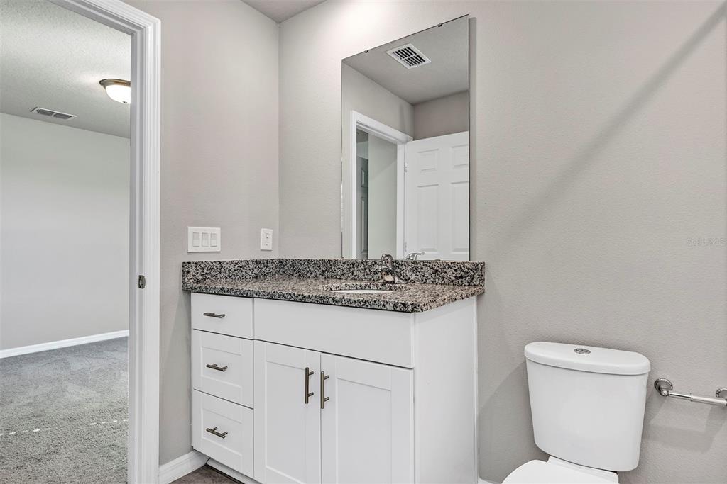 1073 Desert Candle Drive Ocoee, FL 34761 - Photo 32 of 55 a bathroom with a granite countertop toilet and a sink
