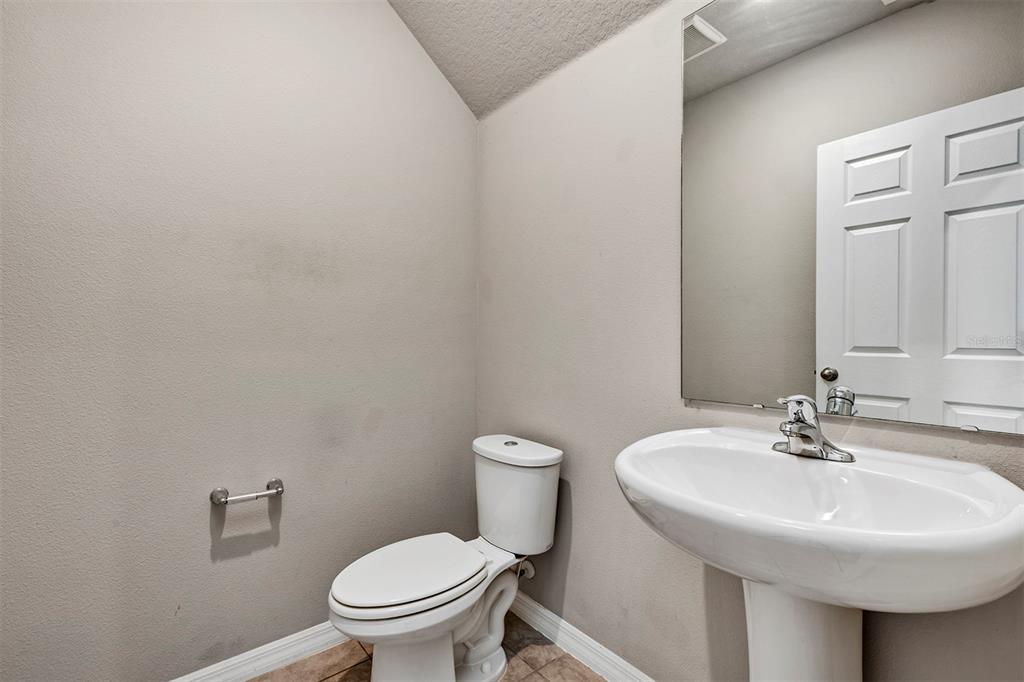 1073 Desert Candle Drive Ocoee, FL 34761 - Photo 34 of 55 a bathroom with a sink a toilet and a mirror