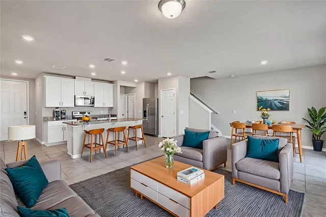 a large white kitchen with kitchen island a sink a stove a microwave and a refrigerator