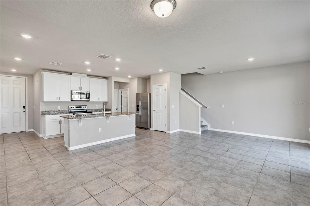1073 Desert Candle Drive Ocoee, FL 34761 - Photo 7 of 55 a large white kitchen with kitchen island a sink a stove a microwave and a refrigerator