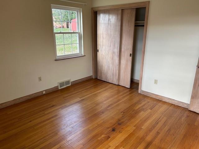 2122 Highway 130 Pleasant Unity, PA 15676 - Photo 8 of 16 an empty room with wooden floor and windows