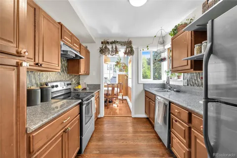 a kitchen with stainless steel appliances granite countertop a stove top oven a sink dishwasher and a refrigerator