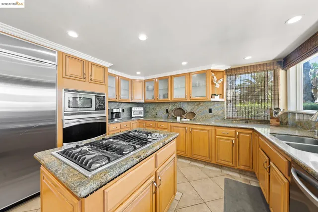 a kitchen with stainless steel appliances granite countertop a stove a sink dishwasher and a refrigerator