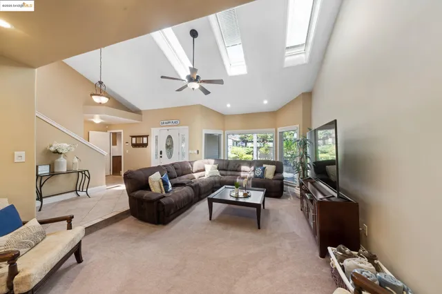 a living room with furniture a flat screen tv and a window