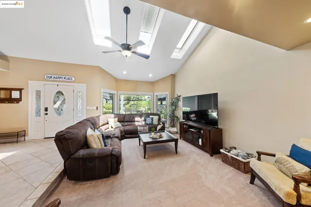 a living room with furniture a flat screen tv and a window