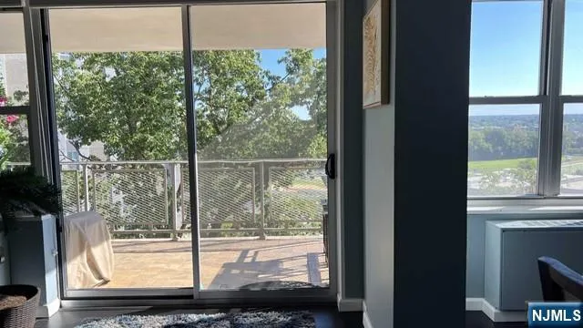 a view of a room with a large window and wooden floor