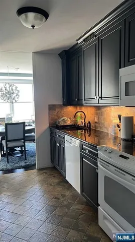 a kitchen with granite countertop a sink and a stove