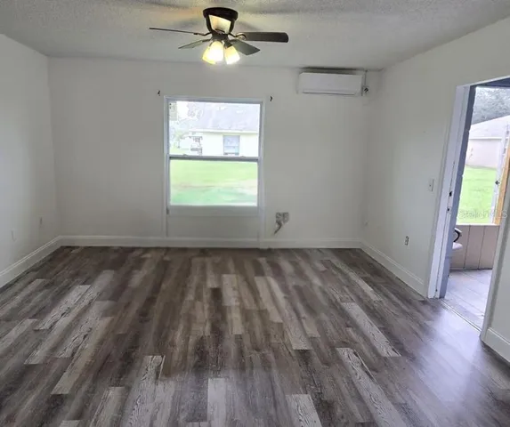 an empty room with a window and wooden floor