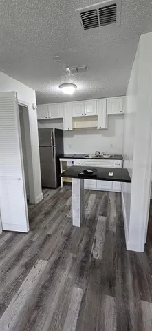 a kitchen with stainless steel appliances granite countertop a refrigerator a sink and a stove