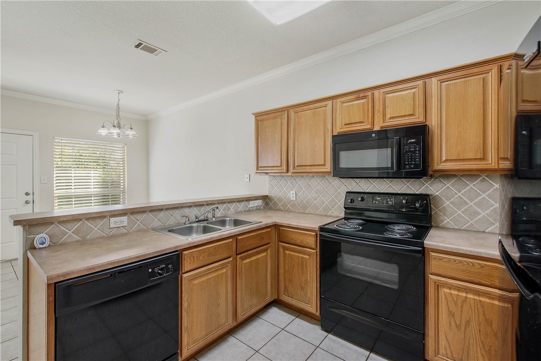 1001 Krenek Tap Road, Unit 702 College Station, TX 77840 - Photo 5 of 15 a kitchen with stainless steel appliances granite countertop a sink stove and microwave