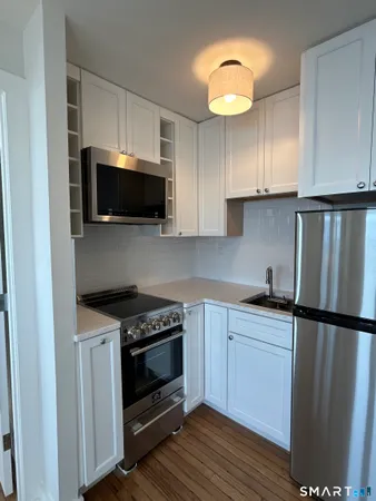 a kitchen with stainless steel appliances a stove microwave and sink