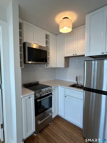 a kitchen with stainless steel appliances a stove microwave and sink