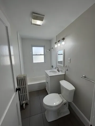 a bathroom with a toilet sink a mirror and a bathtub