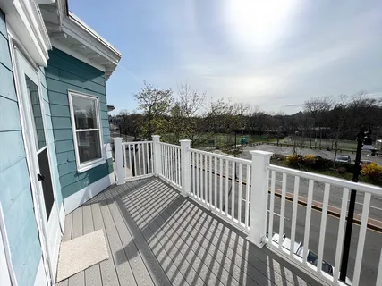 a view of balcony with wooden floor and fence