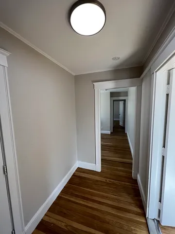 a view of a hallway with wooden floor and staircase