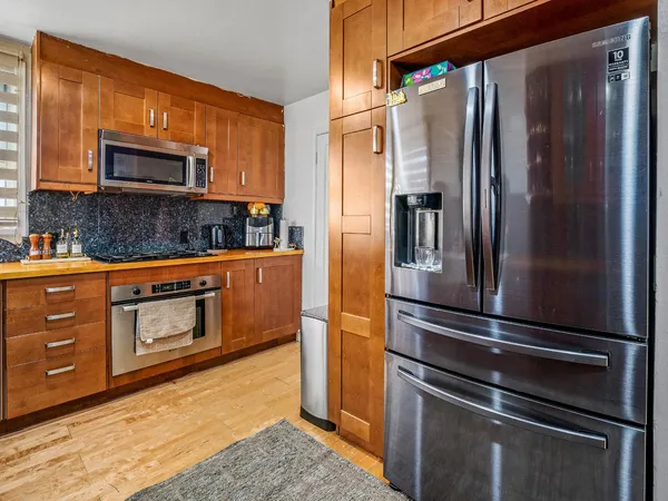 a kitchen with stainless steel appliances granite countertop a refrigerator and a stove
