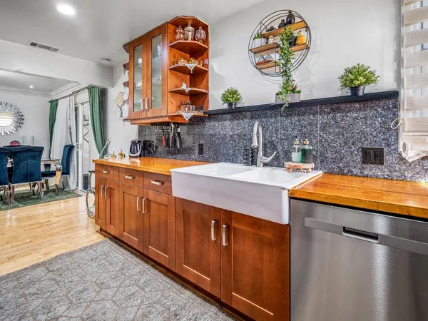 an outdoor kitchen with a sink and large wooden cabinets
