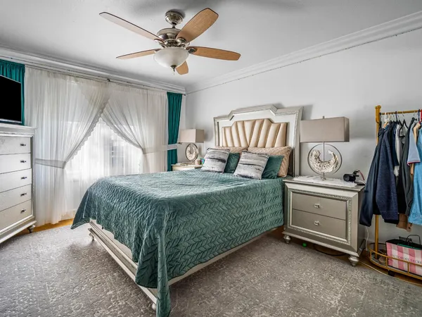 a bedroom with a bed and a flat tv screen on dresser
