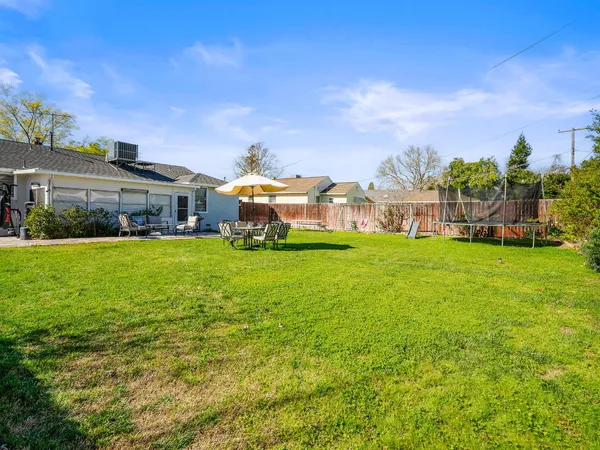 a view of a house with a big yard and large trees