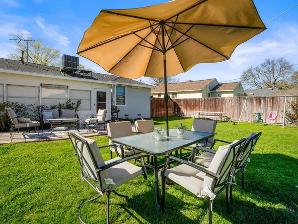 a view of a patio with table and chairs under an umbrella