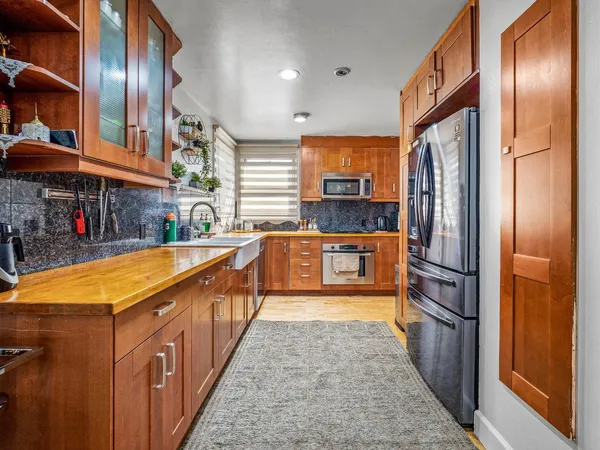 a kitchen with stainless steel appliances granite countertop a stove a sink and a refrigerator