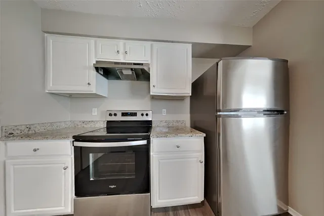 a kitchen with a stove top oven and refrigerator