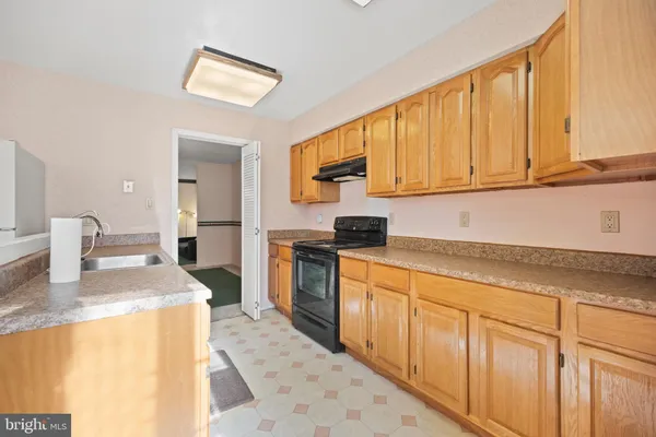a kitchen with granite countertop a sink stove and cabinets