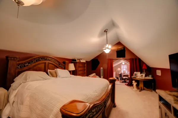 a bedroom with bed and a chandelier