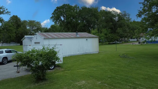 a backyard of a house with plants and large trees