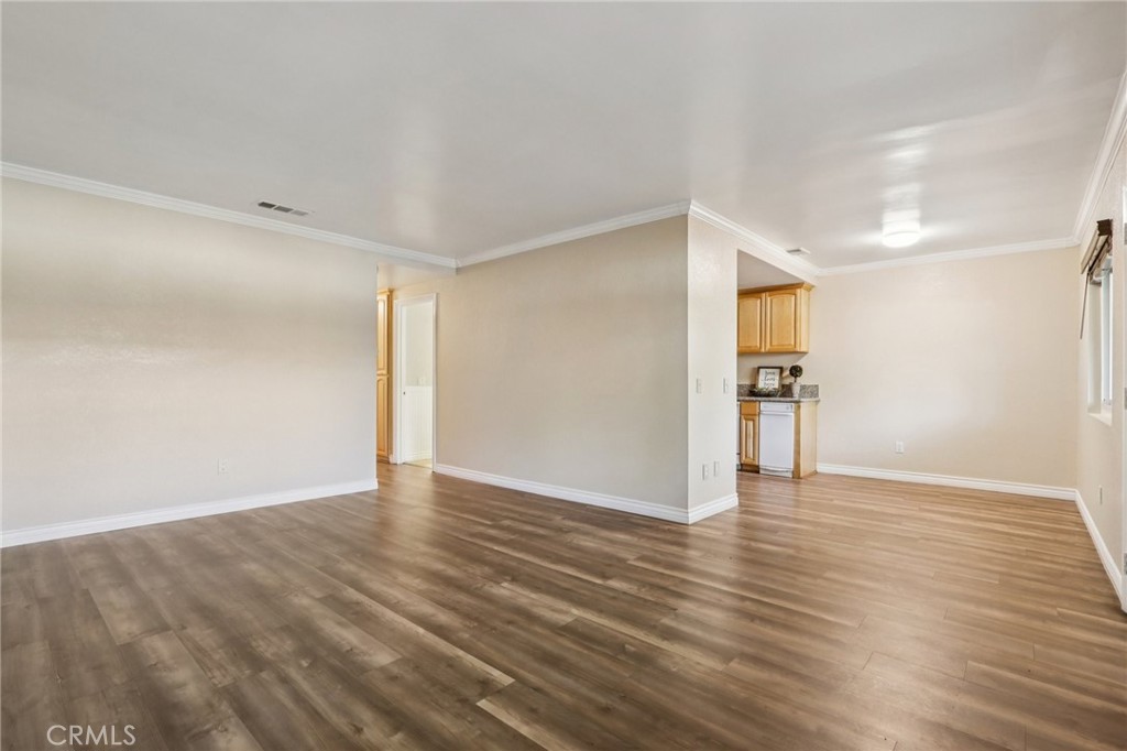 2561 Gonzaga Lane Riverside, CA 92507 - Photo 18 of 48 a view of an empty room with wooden floor and a kitchen